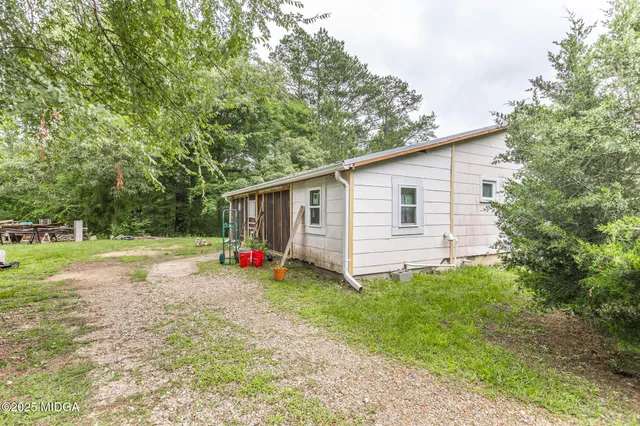 a view of a house with backyard and trees
