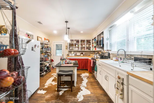 a large kitchen with stainless steel appliances kitchen island granite countertop a sink and cabinets