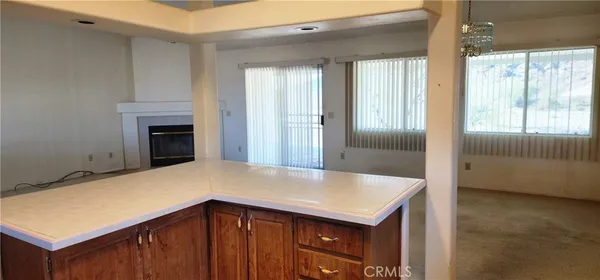 a view of kitchen with granite countertop cabinets and fireplace