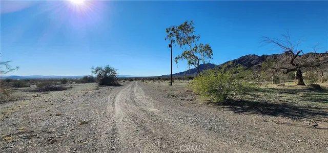 a view of a dry yard with a barn in the background