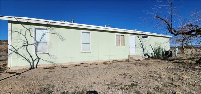 a view of a house with backyard and wooden fence