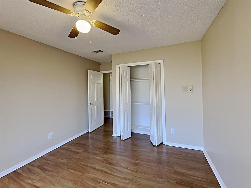 2330 Farm To Market Road 1387 Midlothian, TX 76065 - Photo 11 of 17 an empty room with wooden floor chandelier fan and closet area with wooden floor
