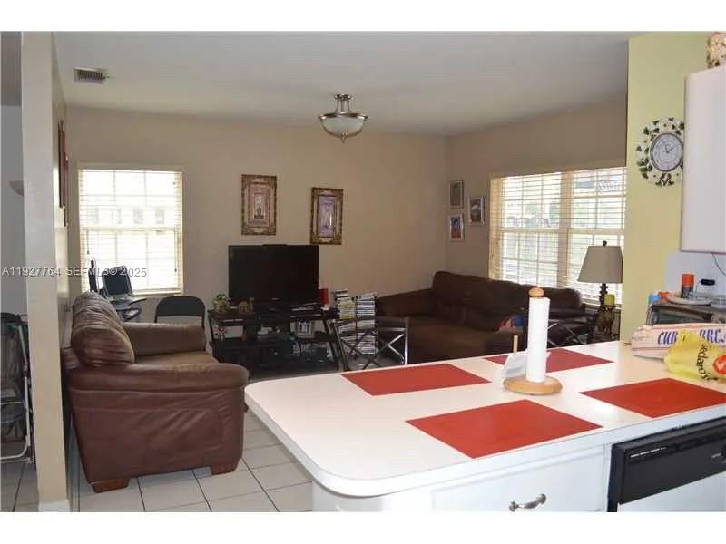 7132 Southwest 158th Path Miami, FL 33193 - Photo 19 of 21 a living room with furniture a flat screen tv and a large window