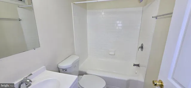 a white toilet sitting next to a bath tub