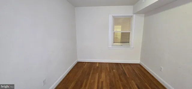 a view of a small space with wooden floor and a window