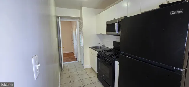 a kitchen with a refrigerator stove and cabinets