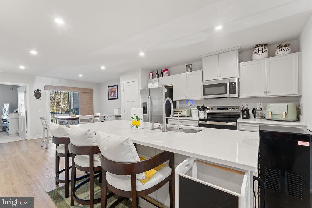 18368 Centennial Circle Ruther Glen, VA 22546 - Photo 10 of 45 a kitchen with stainless steel appliances a table chairs microwave and cabinets