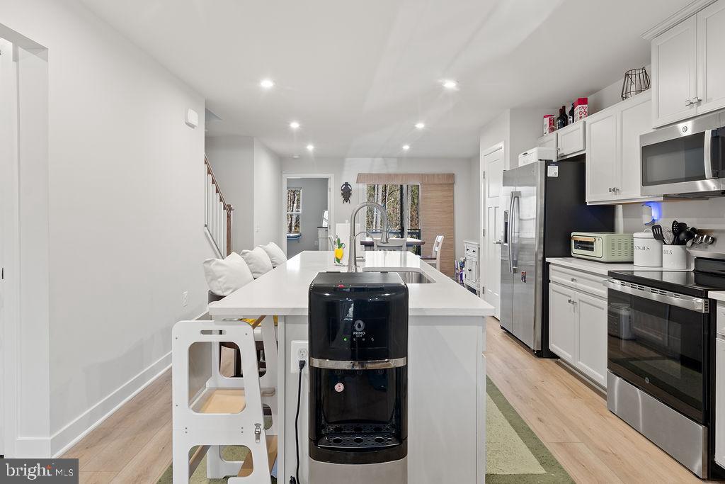 18368 Centennial Circle Ruther Glen, VA 22546 - Photo 11 of 45 a kitchen with kitchen island a white counter top space cabinets and stainless steel appliances