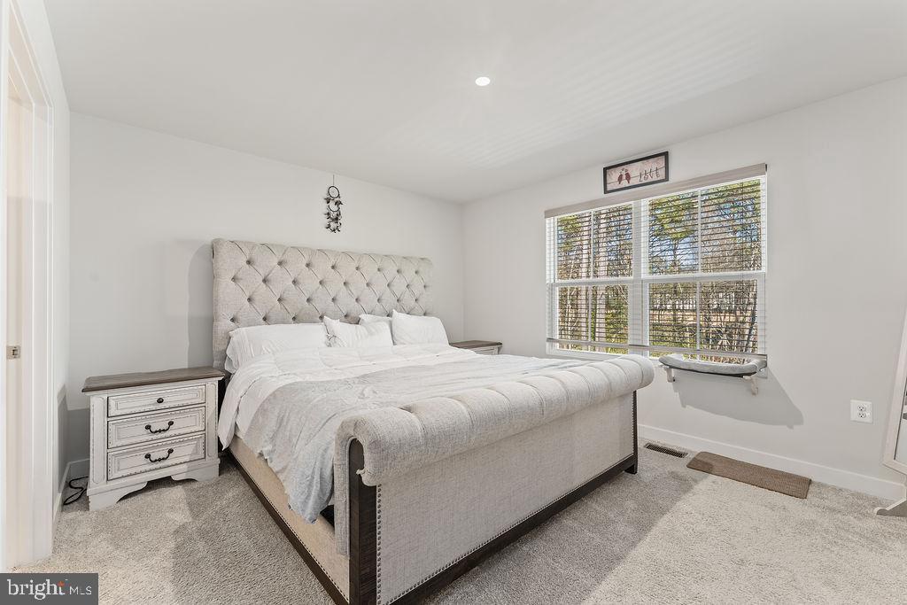 18368 Centennial Circle Ruther Glen, VA 22546 - Photo 17 of 45 a large bed sitting in a bedroom next to a window