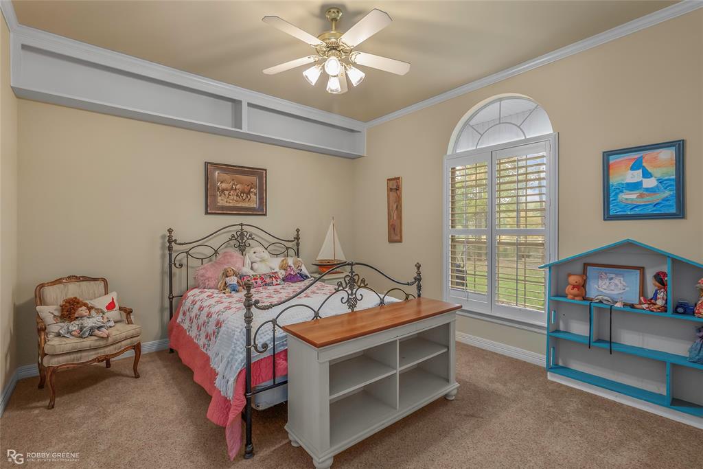 400 Crouch Road Benton, LA 71006 - Photo 26 of 40 a bedroom with a bed and a chandelier