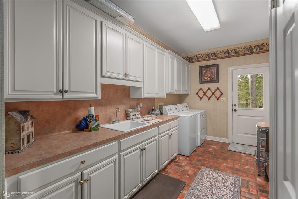 400 Crouch Road Benton, LA 71006 - Photo 29 of 40 Kitchen with decorative backsplash, brown cabinetry, vaulted ceiling, crown molding, and pendant lighting