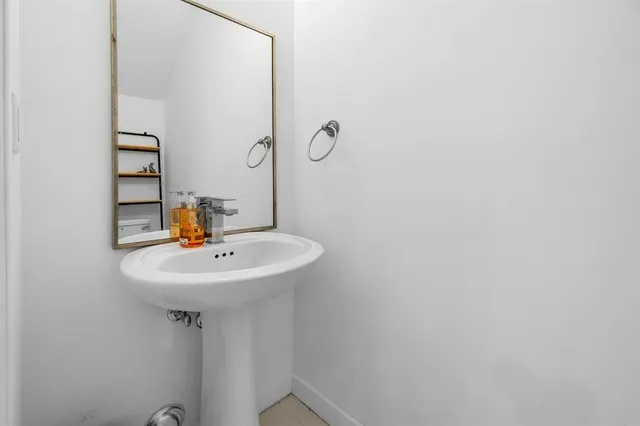 a bathroom with a sink a mirror and shower curtain