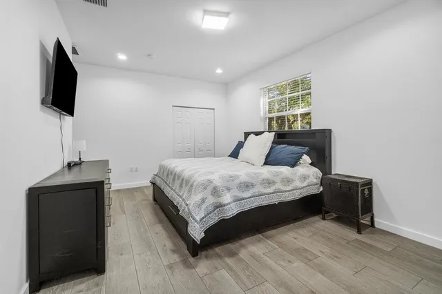 a bedroom with a bed and a flat screen tv