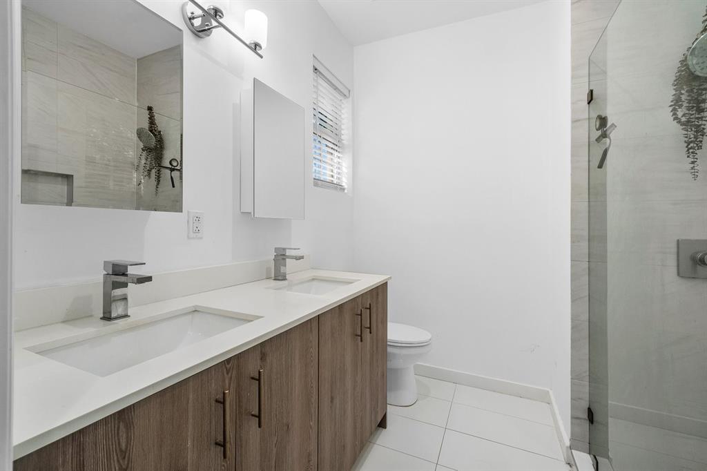 1030 Crystal Way, Unit 104 Delray Beach, FL 33444 - Photo 15 of 44 a bathroom with a sink a toilet and a mirror