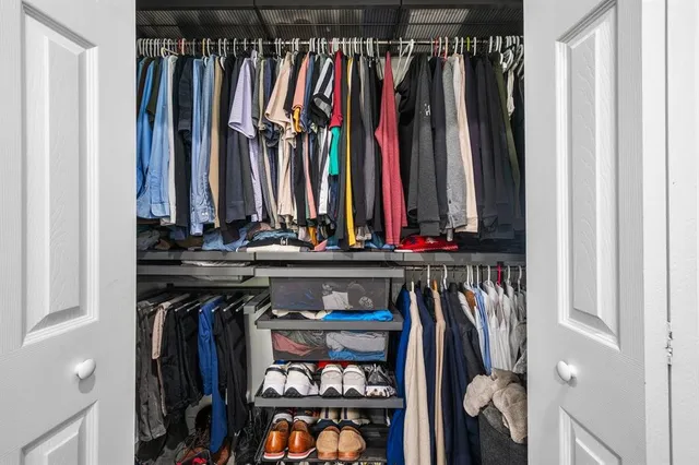 a view of walk in closet with clothes