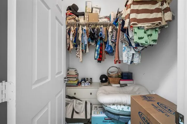 a view of walk in closet with clothes and shoes