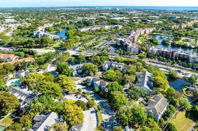 an aerial view of residential houses with outdoor space and trees