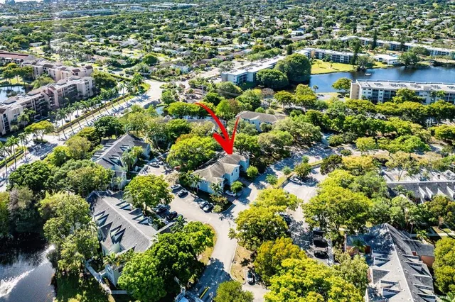 an aerial view of residential houses with outdoor space and trees