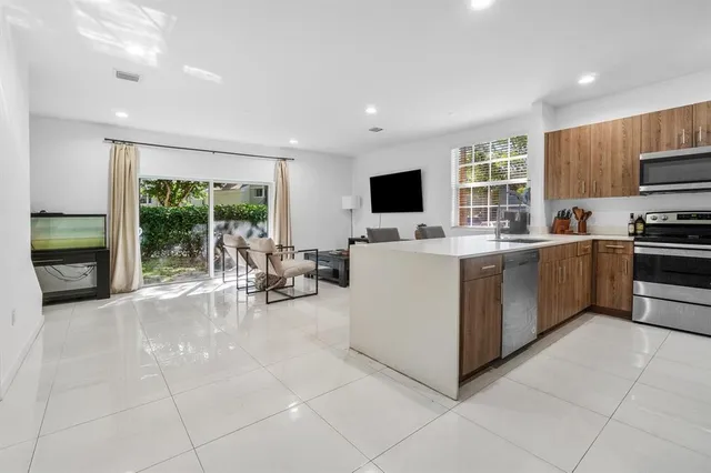 a view of kitchen with sink a microwave and cabinets