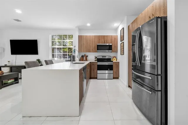 a kitchen with stainless steel appliances a refrigerator stove microwave and sink