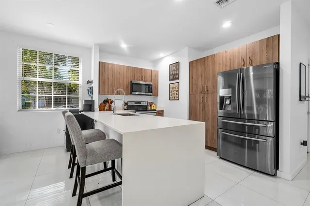 a kitchen with stainless steel appliances a refrigerator and a stove top oven