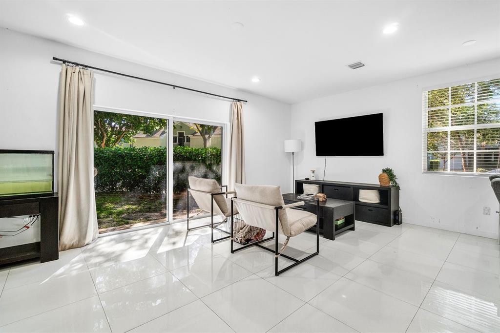 1030 Crystal Way, Unit 104 Delray Beach, FL 33444 - Photo 8 of 44 a workspace with furniture and large windows