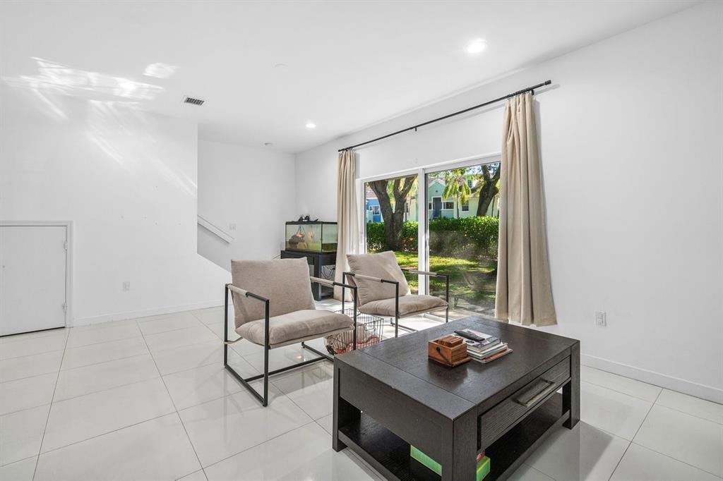 1030 Crystal Way, Unit 104 Delray Beach, FL 33444 - Photo 9 of 44 a living room with furniture and a floor to ceiling window