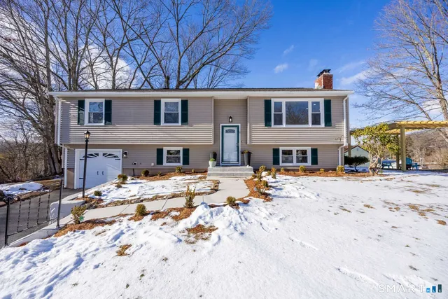 a front view of a house with a yard covered in snow