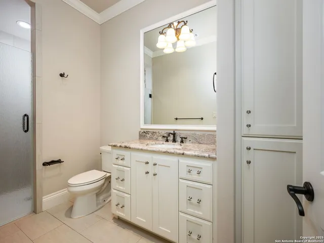 a view of a white house with a yard and table and chairs under an umbrella