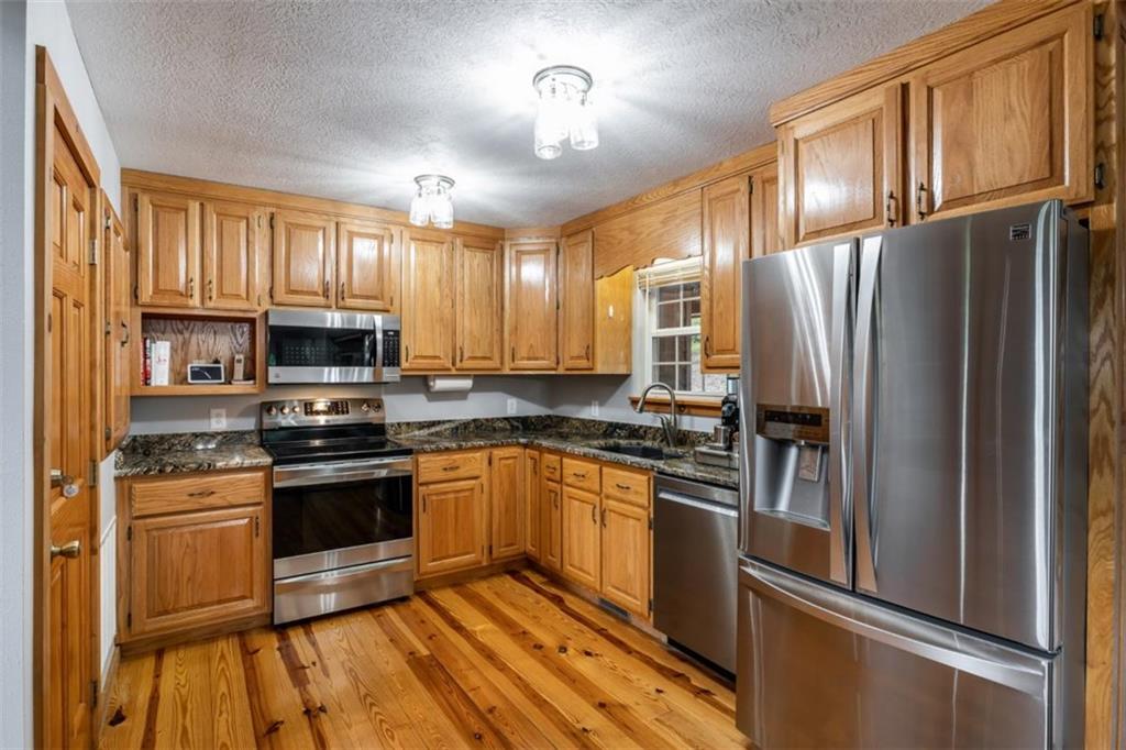 349 Moon Shadow View North Blairsville, GA 30512 - Photo 15 of 74 a kitchen with stainless steel appliances granite countertop a refrigerator stove and sink