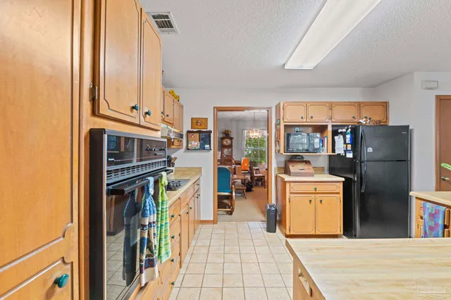 a living room with stainless steel appliances furniture a fireplace and a large window