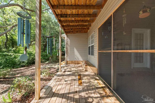 a view of a patio with table and chairs with wooden floor and fence
