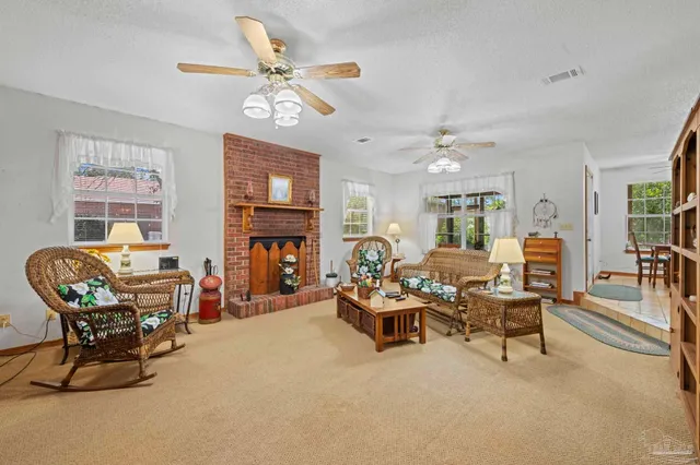 a living room with furniture a fireplace and a chandelier