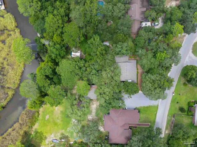 an aerial view of a house with a yard and lake view