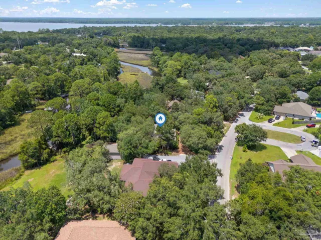 an aerial view of a houses with a yard and lake view