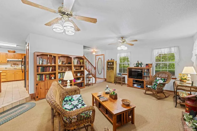 a living room with furniture a chandelier and a flat screen tv