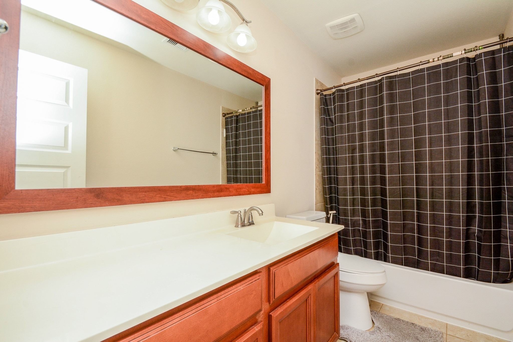 7046 Sliding Rock Circle Spring, TX 77379 - Photo 30 of 41 Elegant upstairs bathroom featuring a spacious vanity, modern lighting, and a stylish shower-tub combo with a sleek curtain.