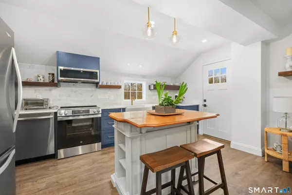 a kitchen with stainless steel appliances granite countertop a stove a sink dishwasher and a refrigerator