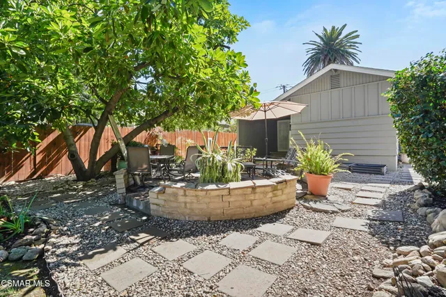 a view of a house with backyard and sitting area