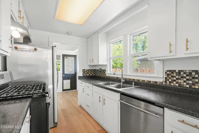 a kitchen with a sink stove and window