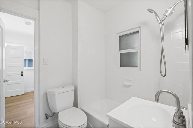 a white toilet sitting next to a bathroom sink
