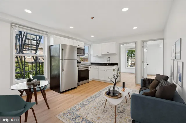 a living room with furniture wooden floor and a refrigerator