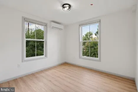 an empty room with wooden floor and a window