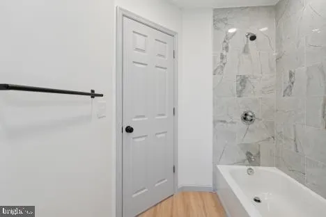 a bathroom with a granite countertop bathtub shower and toilet