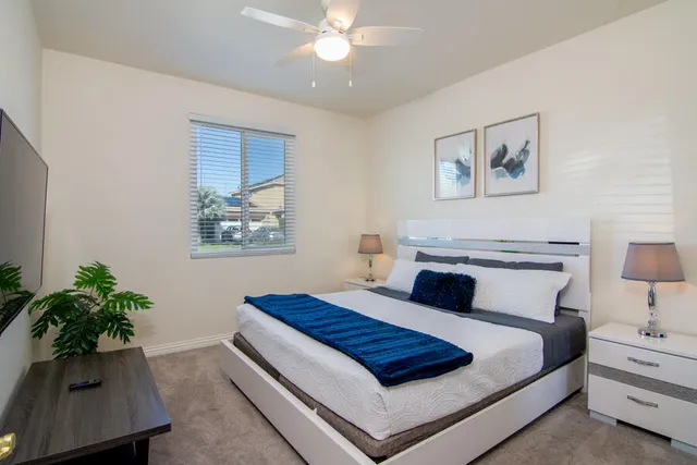 a bedroom with a bed flowers and a potted plant
