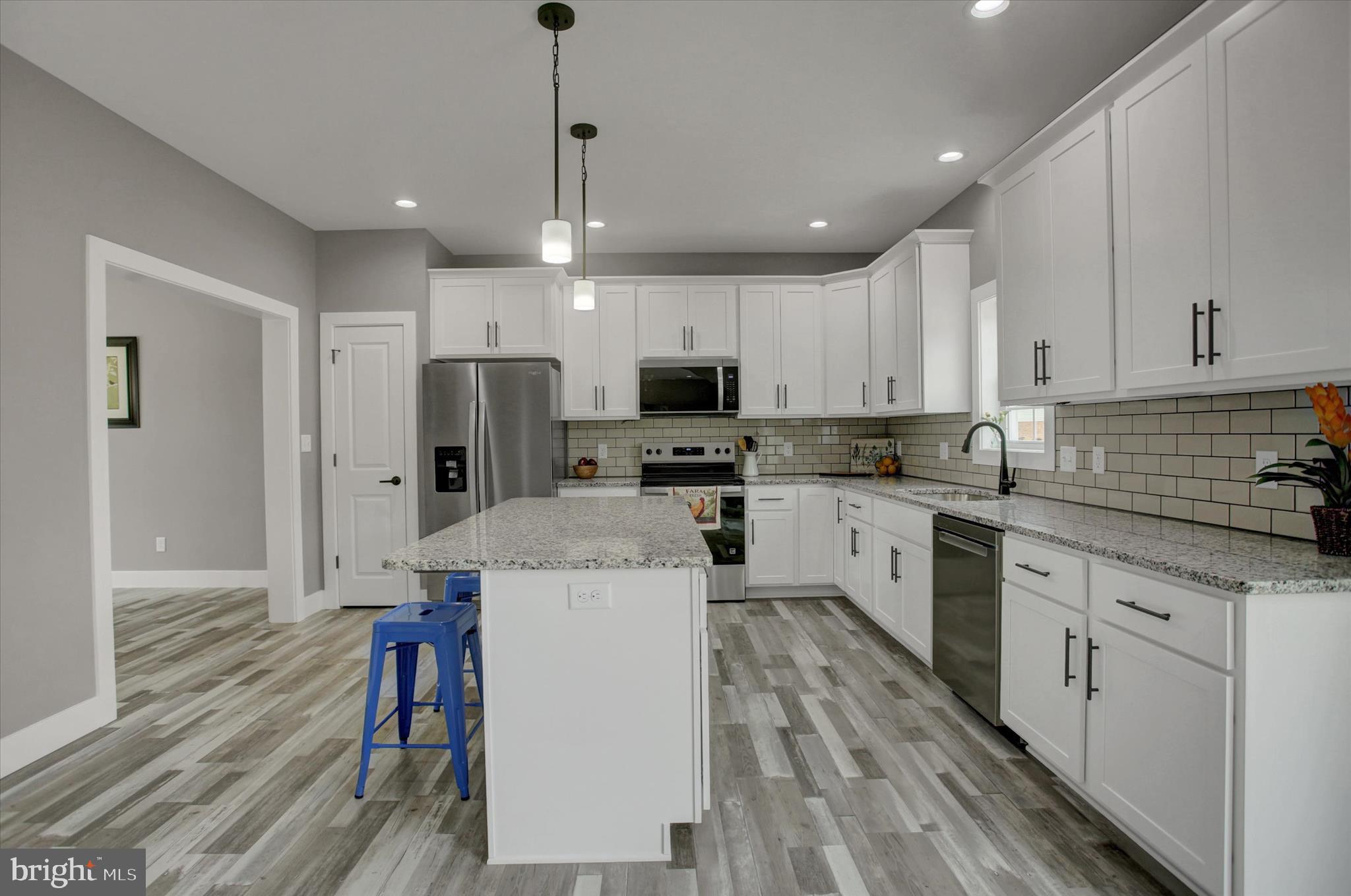 67 James Way Greencastle, PA 17225 - Photo 12 of 41 a kitchen with a refrigerator a stove top oven a sink dishwasher and white cabinets with wooden floor