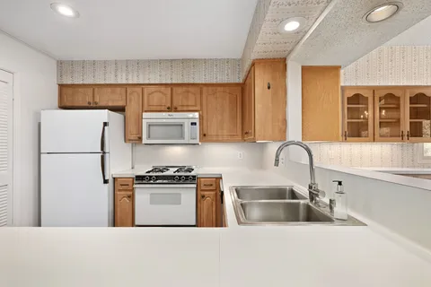 a kitchen with stainless steel appliances a stove a sink a refrigerator a window