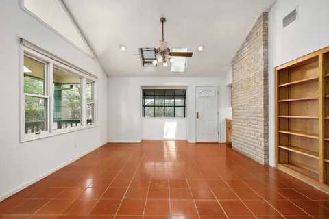 a view of an empty room with a window and fireplace
