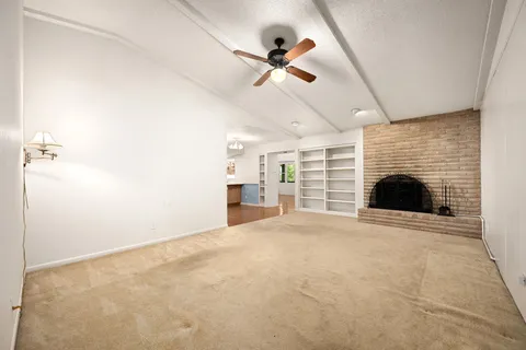 a view of an empty room with a fireplace and a window