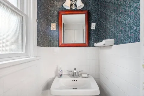 a bathroom with a sink a mirror and a window